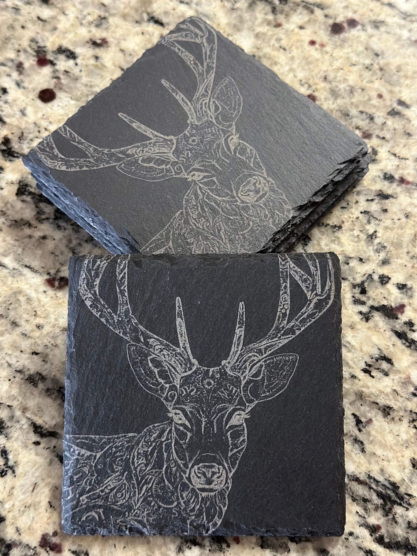 Engraved slate coasters with detailed single deer on a dark slate background.