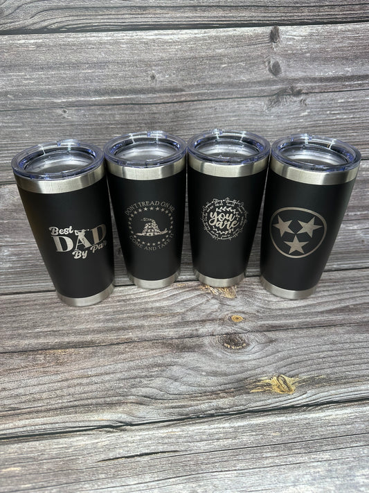 A set of four black 20oz laser engraved stainless steel tumblers with different designs.